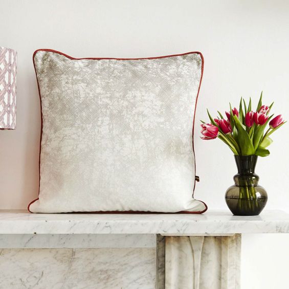 Sophisticated and plush grey pillow with a dazzling red piping