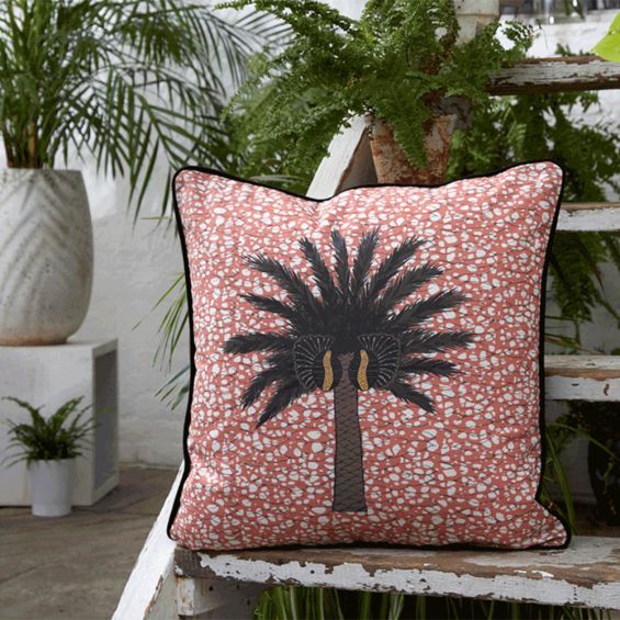 Exuberant tropical design cushion with copper coloured background