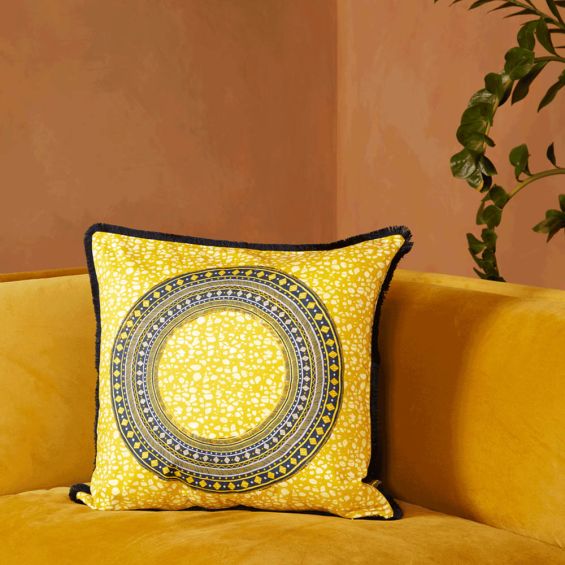 A vibrant cushion by Eva Sonaike with a yellow African-inspired pattern and fringing