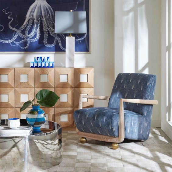 Luxurious blue armchair with faded brown design and brass orb legs