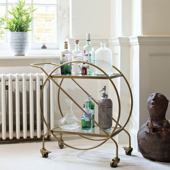 Glamorous drinks trolley with round frame in brass finish