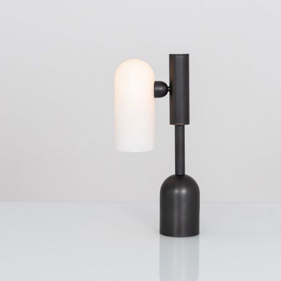 A luxe, industrial black gunmetal table lamp with triplex opal glass