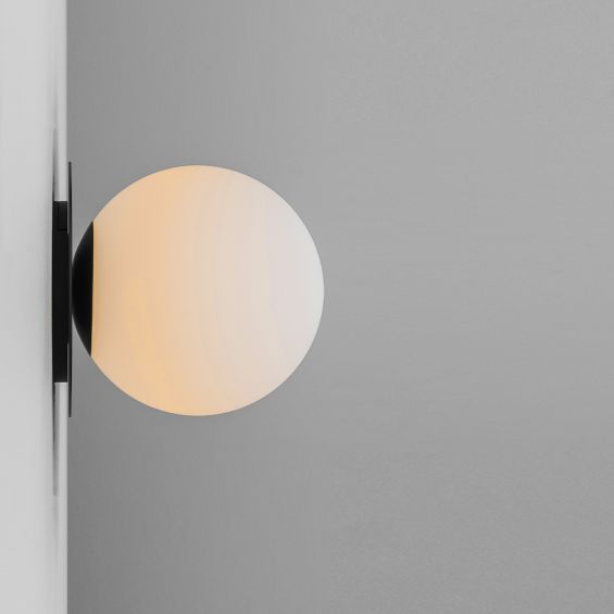 A stylish wall lamp by Schwung with a round, translucent glass shade and beautiful black gunmetal finish