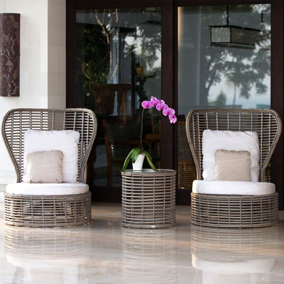 A stylish outdoor side table from Willow's Outdoor collection with a glass table top and woven base