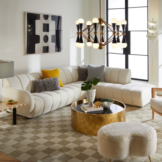 A sumptuous sectional sofa by Jonathan Adler upholstered in an Olympus Ivory bouclé with stylish deep channelled cushions and capsule-shaped arms