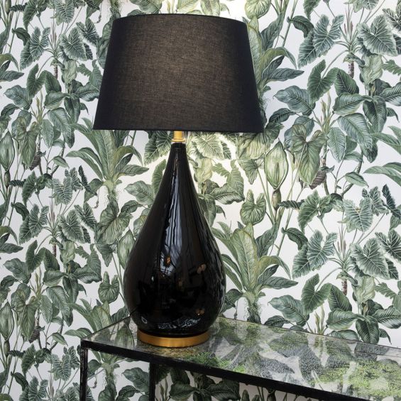 A luxurious black lacquered side lamp with a linen lampshade and brass details