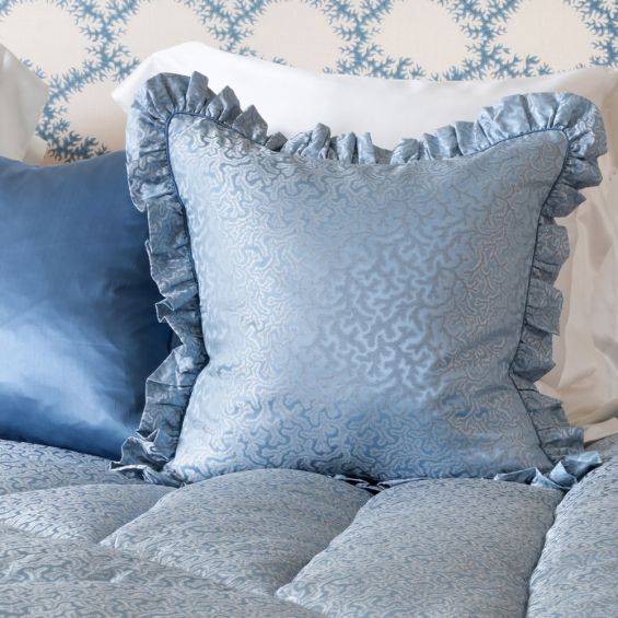 An elegant blue silk cushion with a coral jacquard pattern and frills