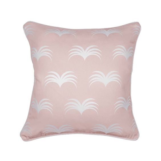 A cute pastel pink cushion with white piping and leaf-like design