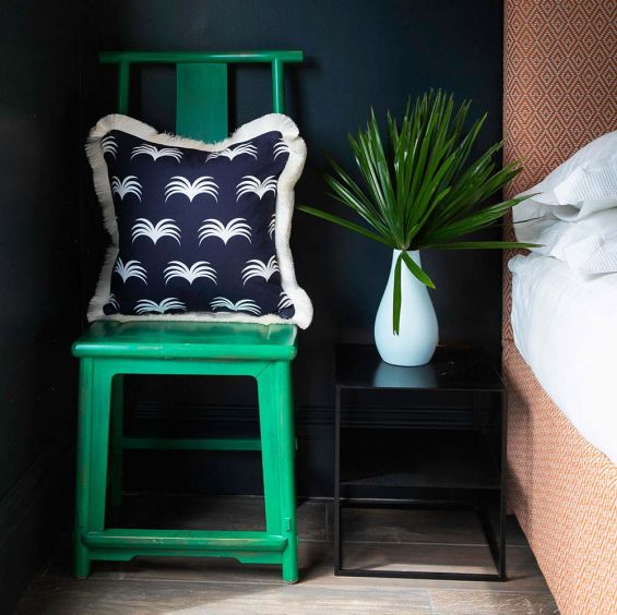 A gorgeous dark blue cushion with a white pattern and elegant fringe