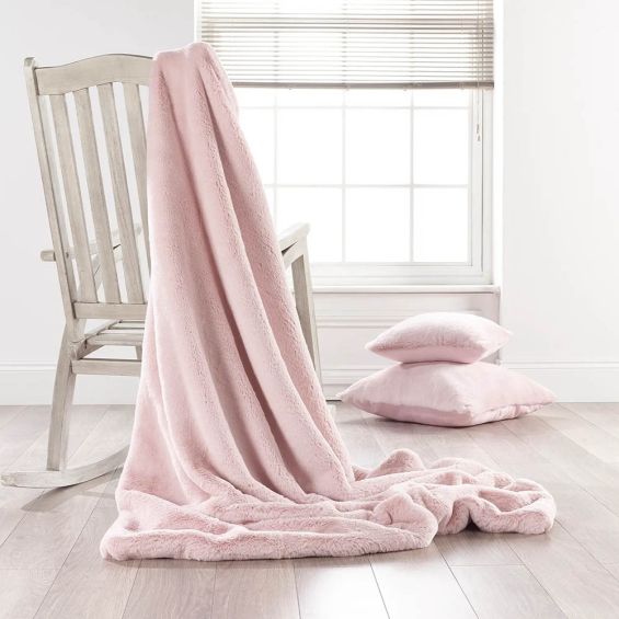 A luxurious soft pink faux fur throw with a barley colour faux suede reverse