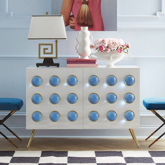 A chic, white lacquer sideboard with acrylic cabochons and brass legs 