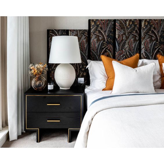 Elegant black bedside with gold frame detail and gold handles