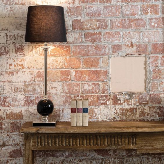 An elegant slender table lamp with black and nickel detailing and a black linen shade