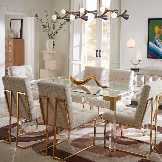 A boucle upholstered dining chair on a brass frame.