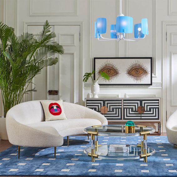 A chic cocktail table by Jonathan Adler with a round, brushed brass and clear acrylic structure 