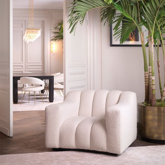 A glamorous armchair by Eichholtz with a boucle fabric upholstery and sumptuous silhouette
