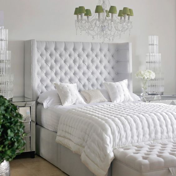 Grand luxury upholstered bed, with deep buttoned headboard, sharp wings and piping detail