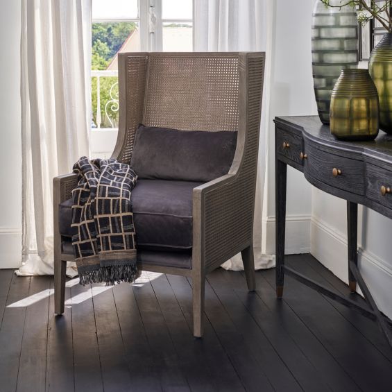 woven armchair with grey velvet cushions 
