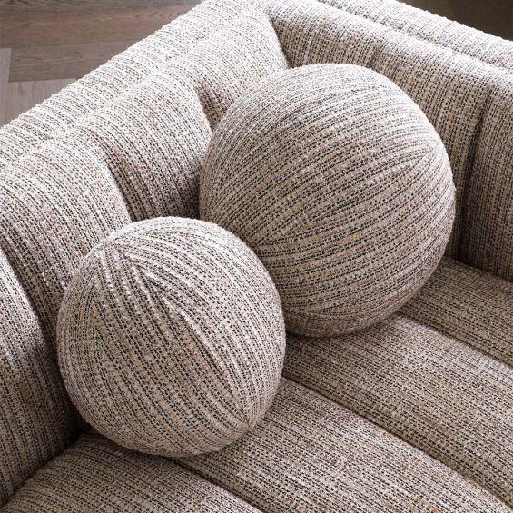 Large, circular pillow in a grainy beige finish.