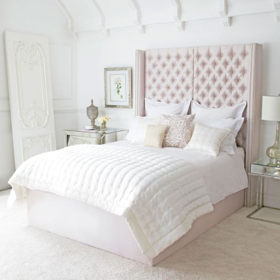 Luxury hotel-style bed with tall deep buttoned headboard and stud detailing