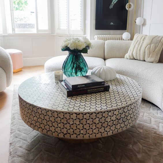A luxury bone inlay coffee table with a round and geometric design elevated on a brass base