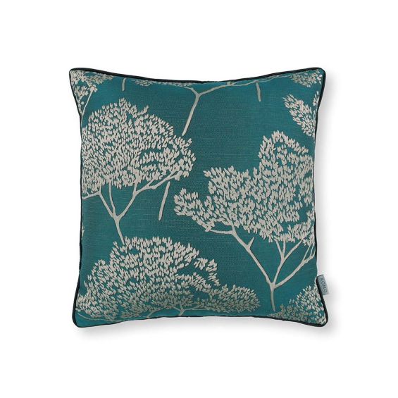 A teal square cushion with tree silhouette details