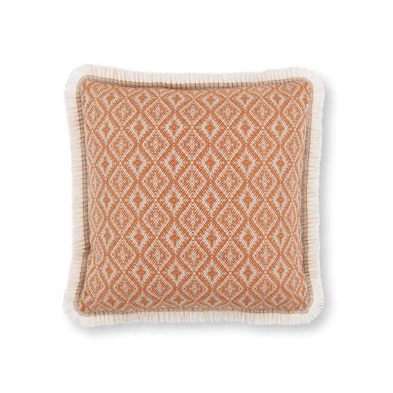 An orange outdoor cushion with diamond pattern and fringe details.