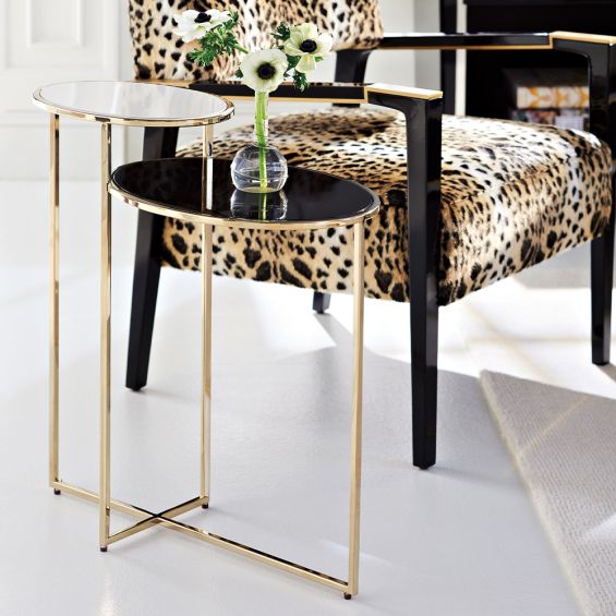 A luxury two-tier side table by Caracole with a glamorous gold base and oval tops