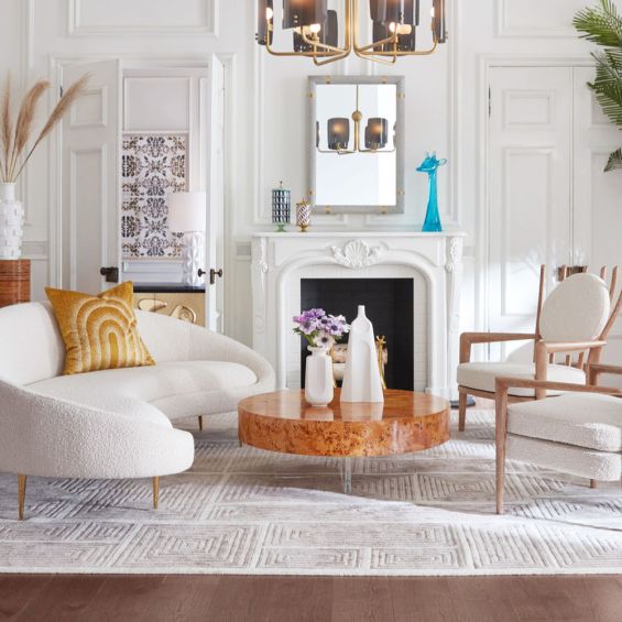 A stylish round cocktail table by Jonathan Adler with a natural burled wood floating surface supported by an X-shaped acrylic base