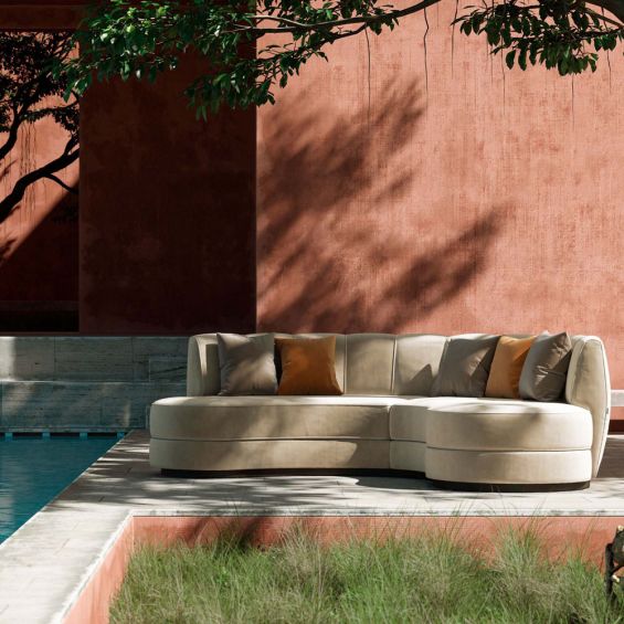 A luxurious beige velvet curved, contemporary design sofa 