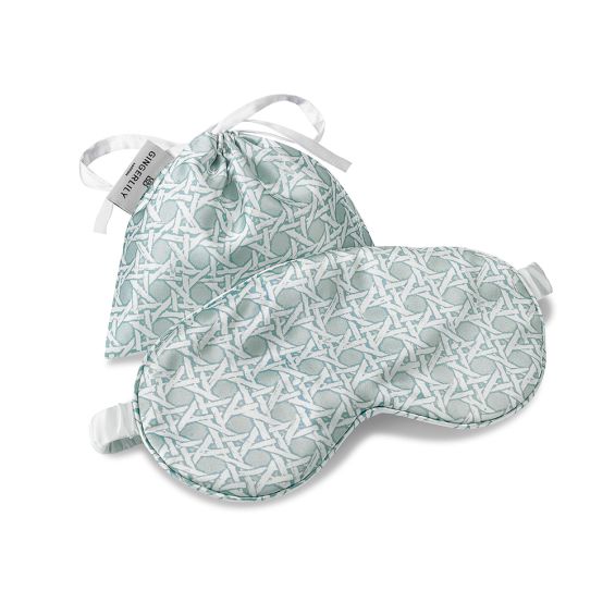 A glamorous silk eye mask with a rattan blue design on a gorgeous ivory background and complete with a drawstring pouch