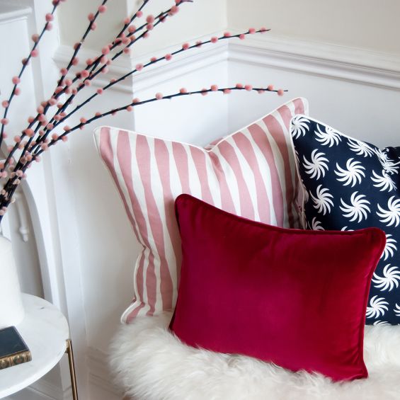 A luxurious red velvet cushion with a rectangular shape