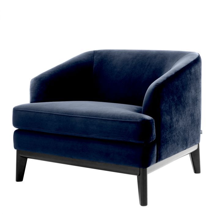 dark blue velvet armchair with exaggerated silhouette