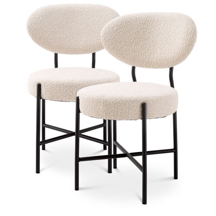 Set of 2 mid-century modern style dining chairs, upholstered in boucle cream with black metal legs.