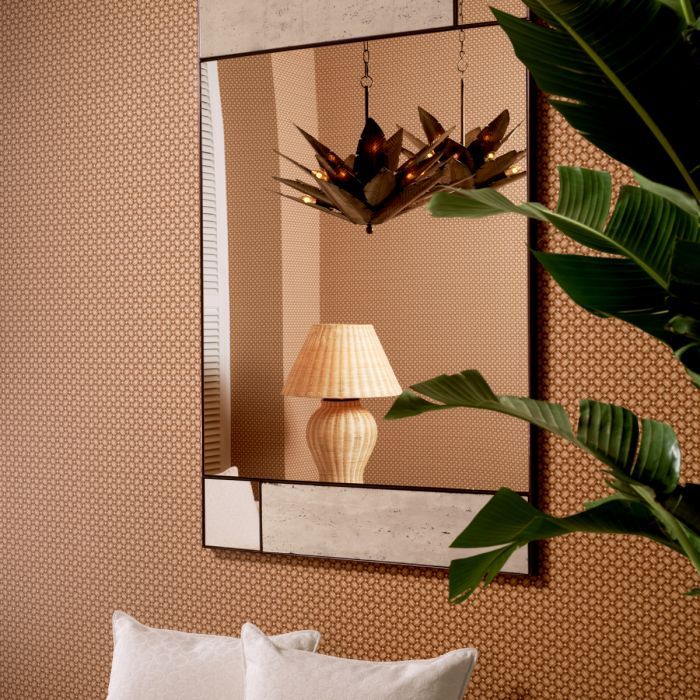 A contemporary wall mirror with travertine elements and a bronze finish
