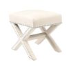 A delicate white velvet footstool adorned with nickel studs.