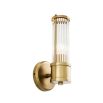 A glamorous wall lamp with an antiqued brass finish and reeded glass
