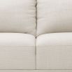 Designer contemporary shaped sofa with oversized arms and overfilled cushions on sharp legs upholstered in a natural fabric