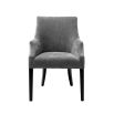 A beautiful grey velvet dining chair with black legs and antique brass studs