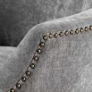 A beautiful grey velvet dining chair with black legs and antique brass studs