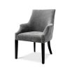 A beautiful grey velvet dining chair with black legs and antique brass studs