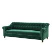 green velvet sofa with buttoning and brass accents 