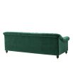 green velvet sofa with buttoning and brass accents 