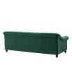 green velvet sofa with buttoning and brass accents 