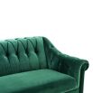 green velvet sofa with buttoning and brass accents 