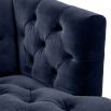 dark blue deep-buttoned sofa with velvet upholstery and black legs with gold accents