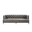 grey deep-buttoned sofa with velvet upholstery and black legs with gold accents