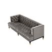 grey deep-buttoned sofa with velvet upholstery and black legs with gold accents