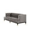 grey deep-buttoned sofa with velvet upholstery and black legs with gold accents