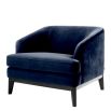 dark blue velvet armchair with exaggerated silhouette